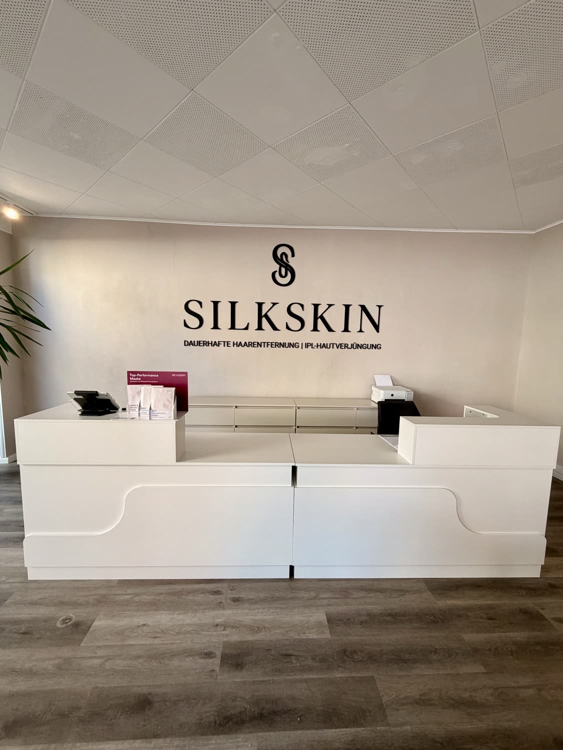 Accueil de SILKSKIN avec le logo au mur